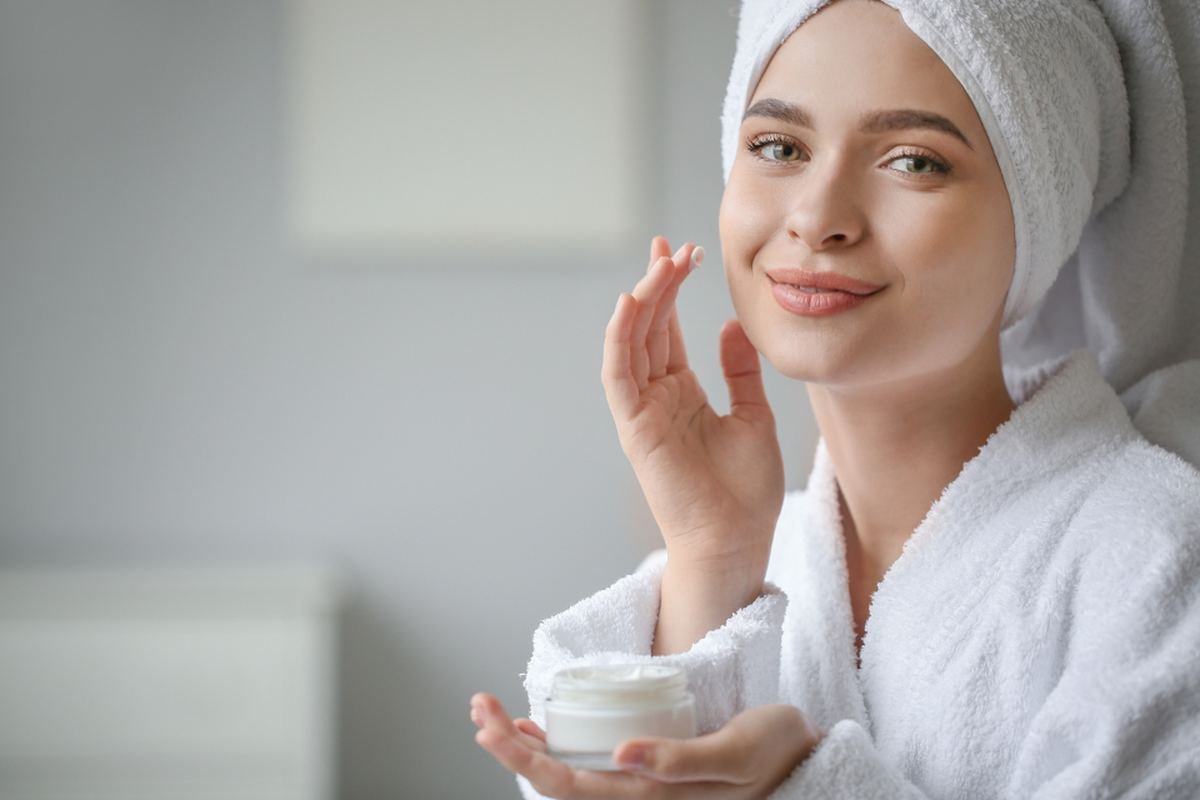 Mulher aplicando creme facial após o tratamento